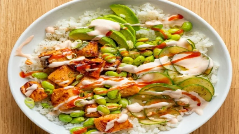 Air Fryer Salmon Rice Bowl with white rice, avocado, edamame, cucumber slices, and creamy sauce for a healthy high-protein meal.