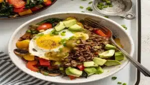 Ground Beef Protein Bowl with fried egg, avocado, sautéed vegetables and healthy toppings.