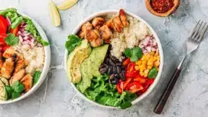 High Protein Chicken Burrito Bowl with grilled chicken avocado rice black beans corn and fresh vegetables.