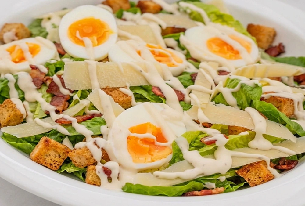 Keto Chicken Caesar Salad Bowls with soft boiled eggs, parmesan cheese, crispy croutons and creamy Caesar dressing.
