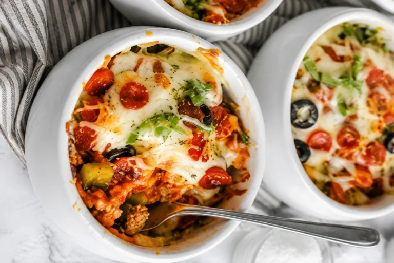 Low-Carb Pizza Bowls topped with melted mozzarella cheese, pepperoni, olives, green peppers, and pizza sauce in white ceramic bowls.
