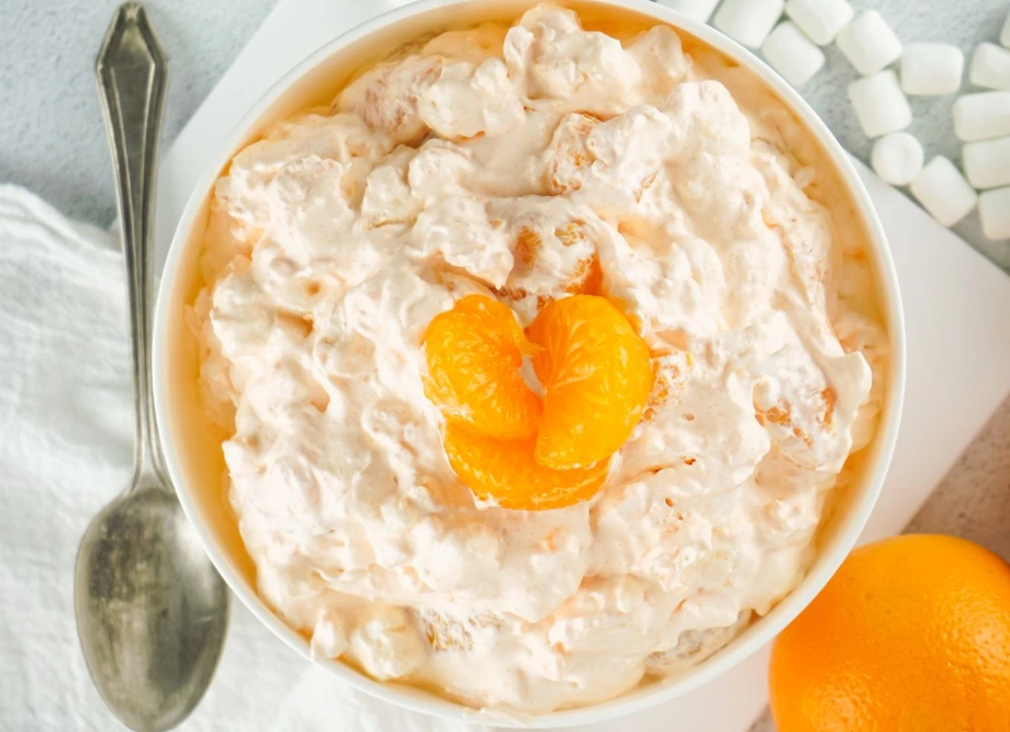 Orange Creamsicle Cottage Cheese Dessert served in a white bowl, topped with juicy mandarin orange segments, featuring a creamy, fluffy texture perfect for a high-protein healthy dessert.