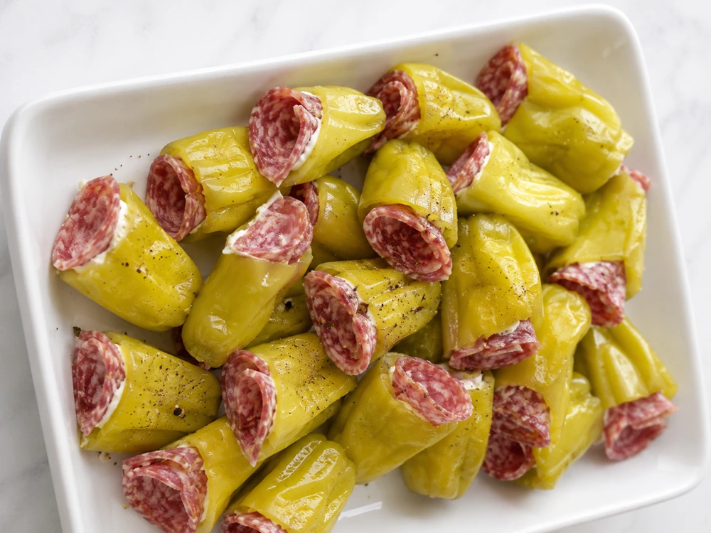 PEPPERONCINI STUFFED PEPPERONI appetizer served on a white platter with creamy cheese filling and Italian salami slices.