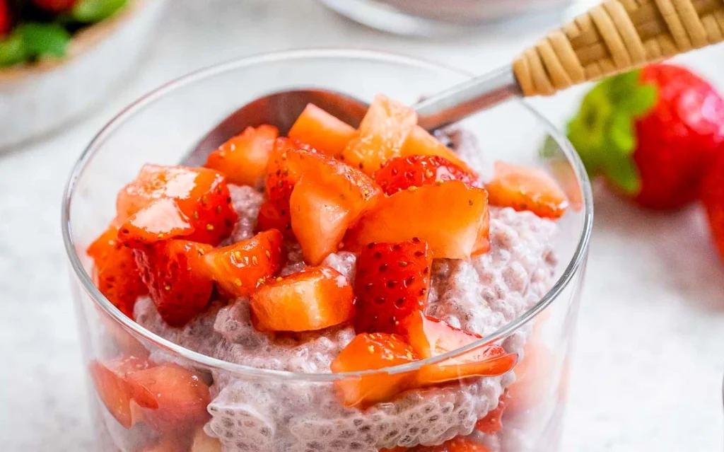 Strawberry Chia Pudding topped with fresh strawberries in a glass bowl, creamy healthy high-protein breakfast