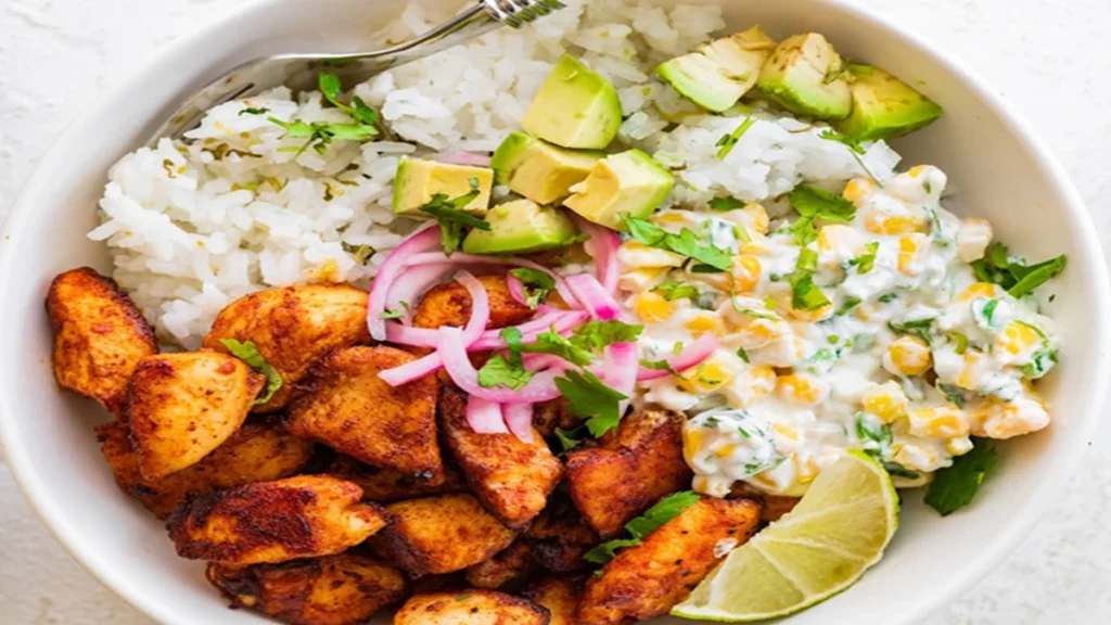 Street Corn Chicken Rice Bowl topped with avocado, pickled red onions, and fresh cilantro