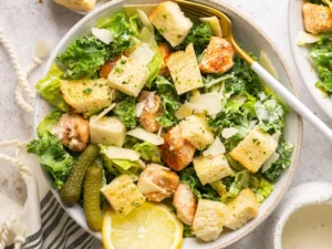 Chicken Caesar Meal Prep bowl topped with grilled chicken, crispy croutons, fresh romaine lettuce, kale, shaved Parmesan cheese, and creamy Caesar dressing.