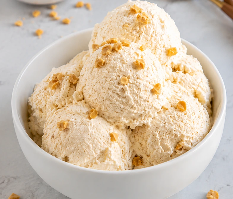 Creamy Cottage Cheese Ice Cream served in a white bowl, topped with crunchy nut pieces. This high-protein frozen dessert has a rich texture and healthy ingredients, making it a delicious guilt-free treat.