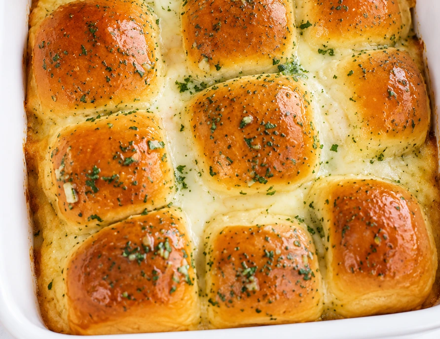 Creamy Garlic Alfredo with Tender Cabbage baked in a white casserole dish, topped with golden dinner rolls, melted cheese, and garlic herb seasoning.