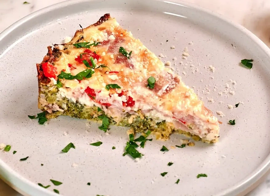 Cheesy Broccoli Quiche with No Pastry Crust served on a white round plate, featuring a fluffy egg filling, broccoli, melted cheese, and herbs for a healthy low-carb meal.