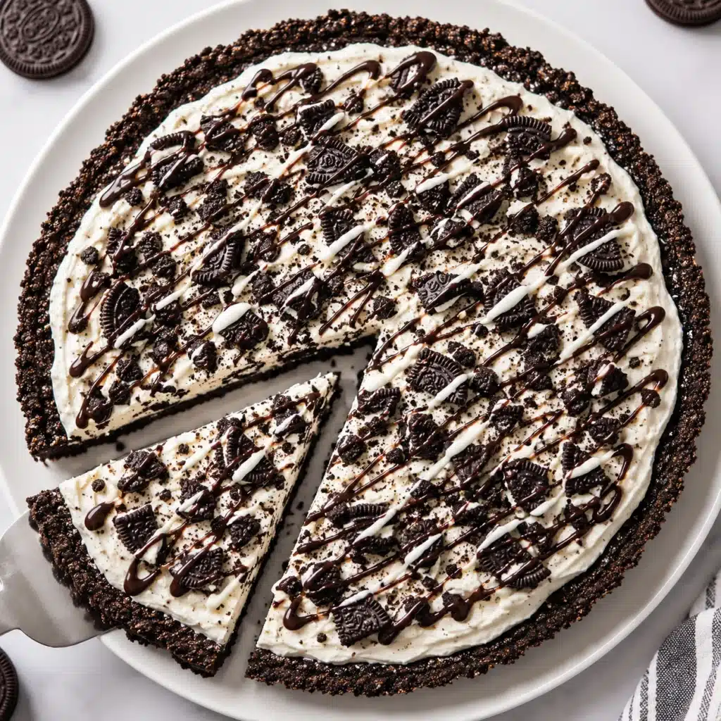 Oreo Dessert Pizza with a crunchy Oreo cookie crust, creamy no-bake filling, crushed Oreo cookies, and chocolate drizzle served on a white plate.